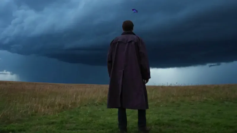 Hombre solo con cometa ante la tormenta