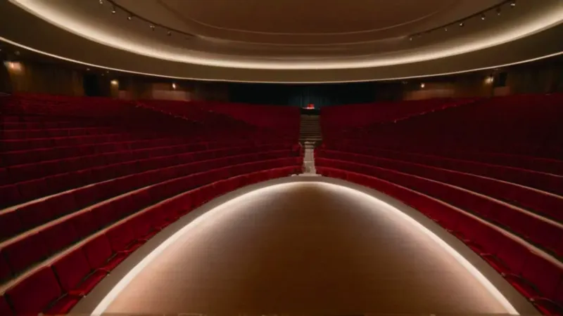 Inmenso auditorio vacío con una figura solitaria