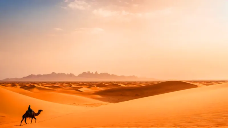Un viajero atraviesa el desierto al atardecer