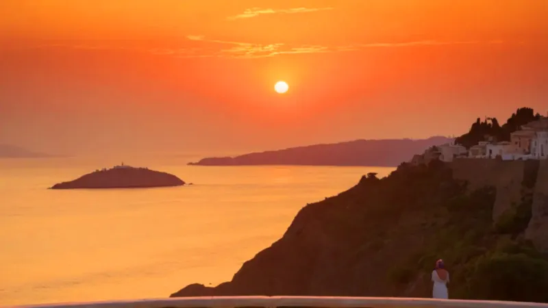 Una silueta contempla el atardecer dorado