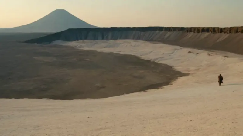 Figura solitaria en un desolado paisaje volcánico