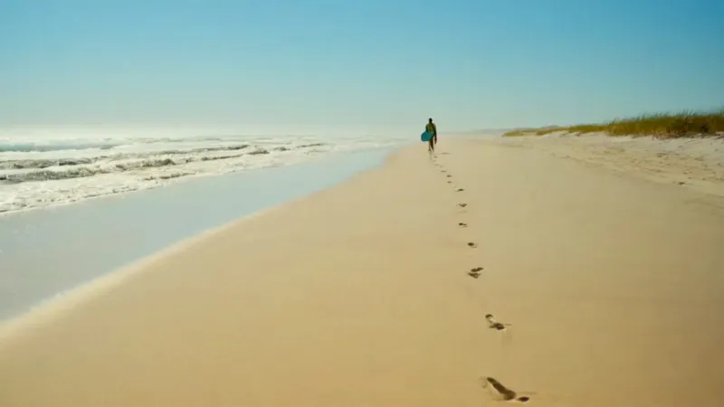 Un surfista solitario camina hacia el mar