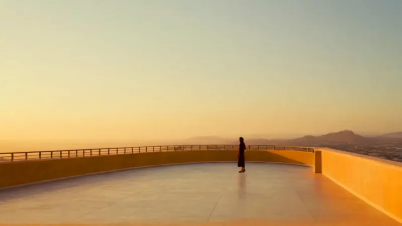 Una figura contempla la ciudad al atardecer