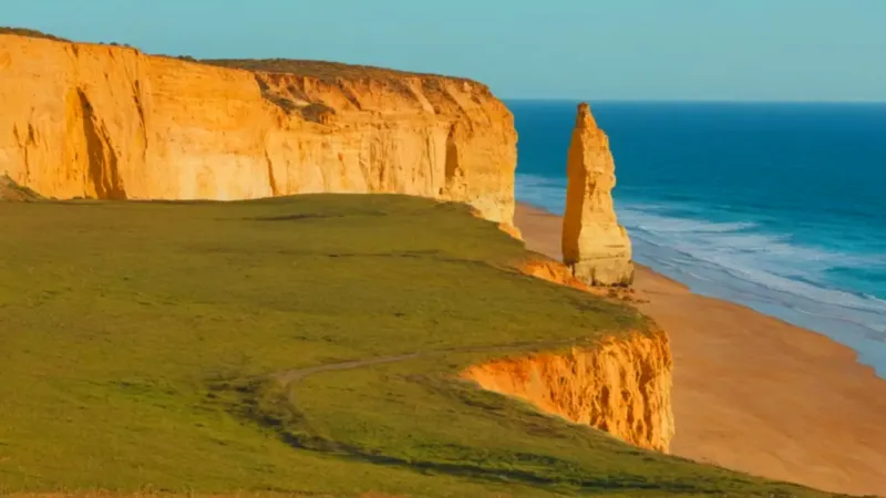 Hombre en acantilado contempla el vasto océano