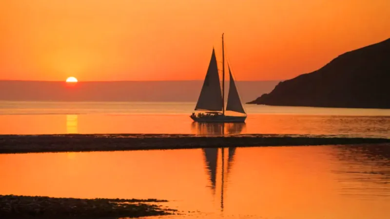 Un velero surca un mar de fuego