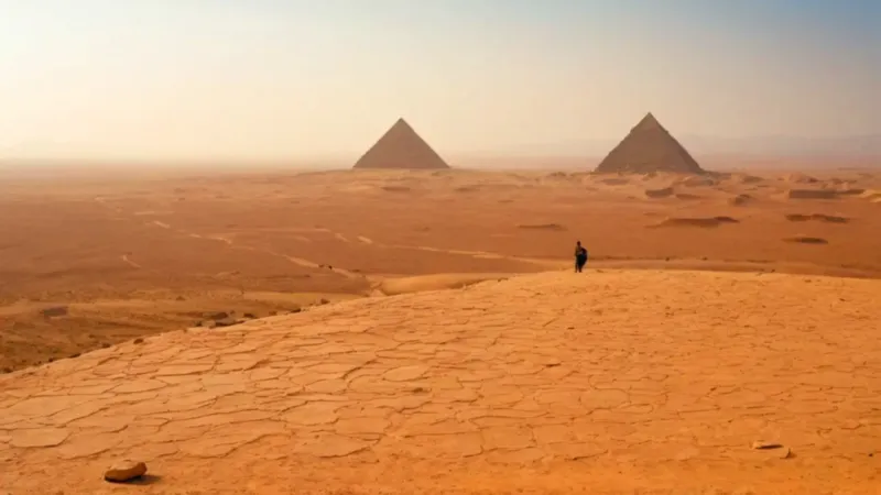 Un solitario contempla las pirámides del desierto
